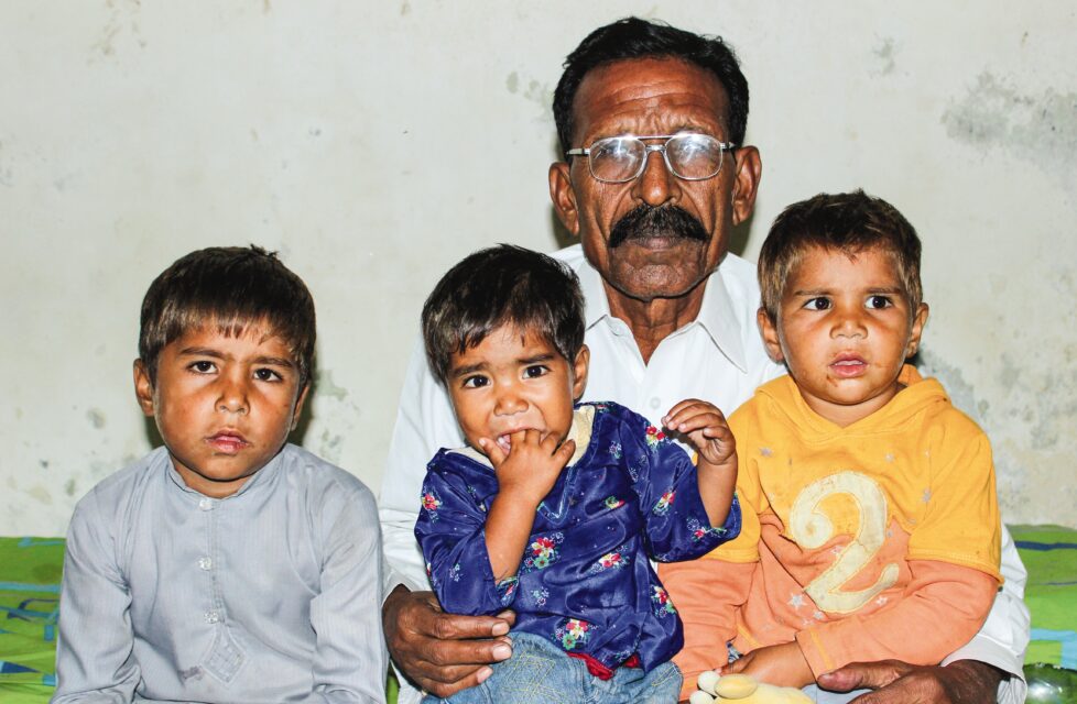 A man sits with his three kids