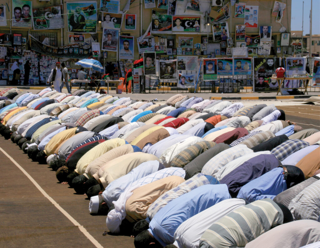 group of hindu people bowing in  prayer 