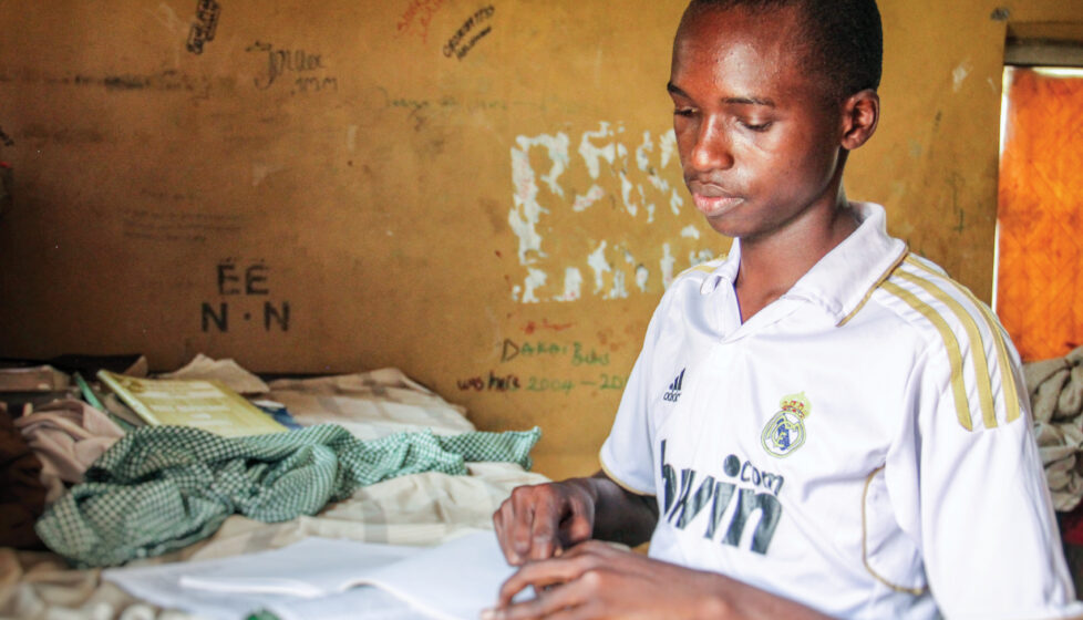 A boy sits at his desk and reads the bible