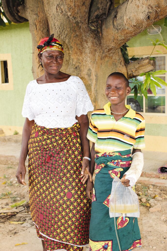 boy stands outside with his mother 