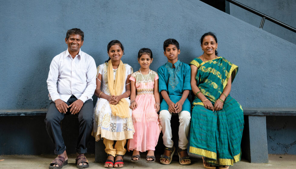 Indian family smiling together sitting on bench