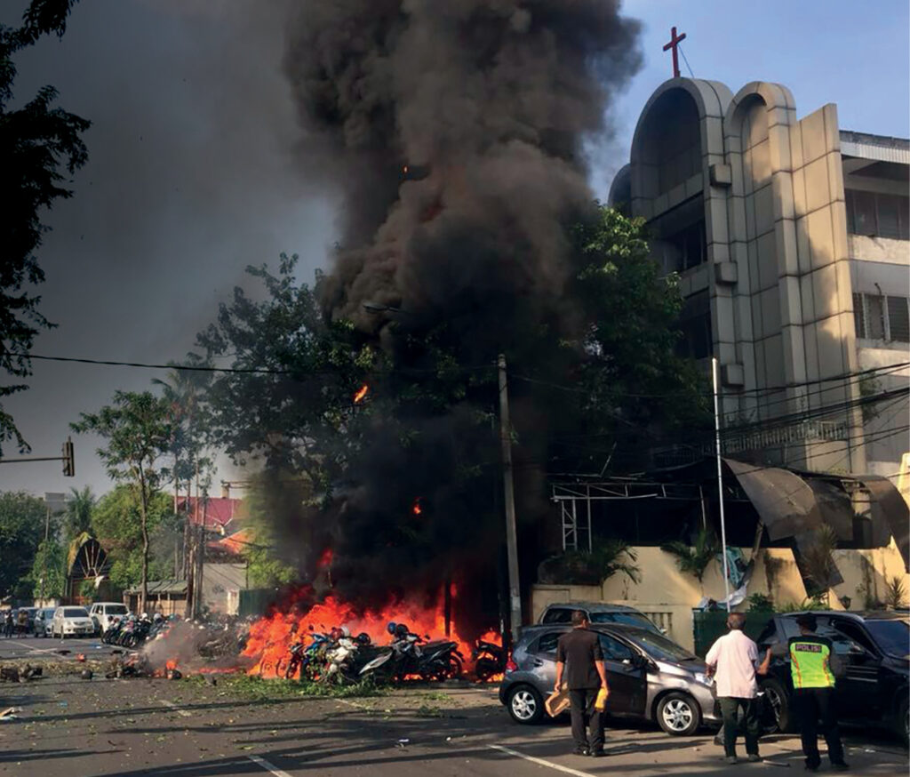 Entrance to the church is on fire. Black smoke and flames are pictured.