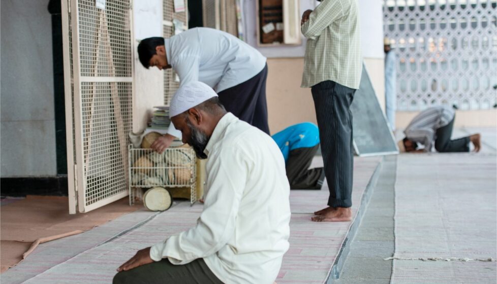 Muslims kneel in front of wall