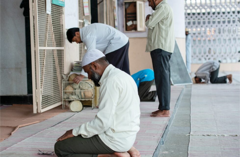 Muslims kneel in front of wall